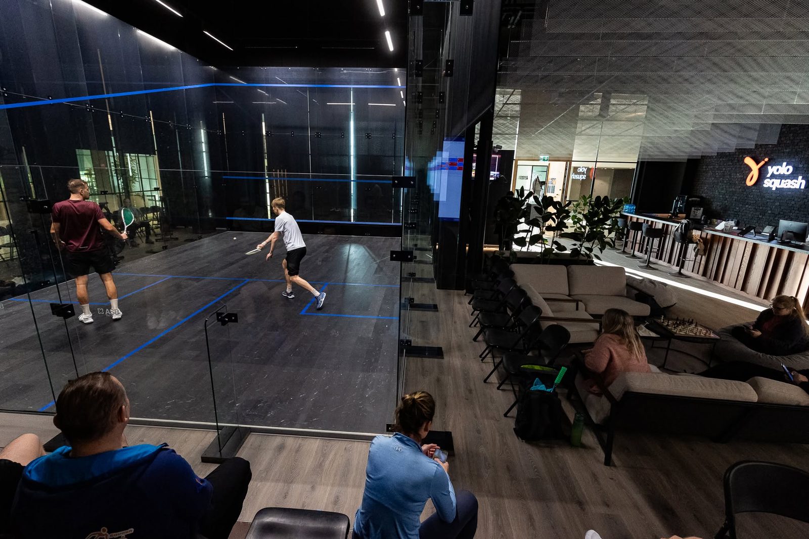 Glass-back court, lounge and reception at YOLO Squash, Tallinn
